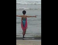 Lady wears black leggings pink scarf beach