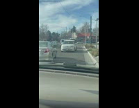 Woman driving white car on intersection