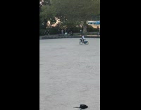 Man drives bike with trash can on his head at the park