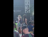 Woman in leather skirt poses beside metal frame