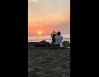 Girl black cowboy hat hold sunset beach