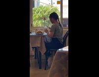 Girl photographs food white tablecloth steel pitcher 