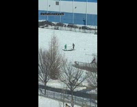 Guys kick ball on patch of grass