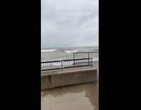 Large wave hits guy paddling on surfboard 