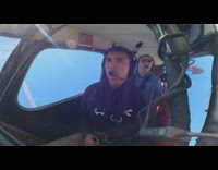 Guy flies small red plane with trainer