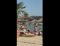 Bikini girl poses beach straw umbrella daybed 