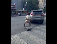 Guy rides skateboard with chair on street
