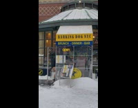 Three guys in jacket and speedos run inside cafe from cold outdoors