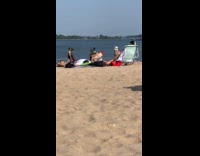 Man taking selfies with rooster at beach