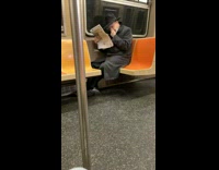 Guy riding subway picks nose black hat 