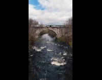 Drone shot train pass by bridge over creek
