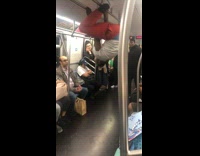 Guy red pants spins and flips on handles and poles on subway train