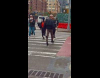 Guy walks and wear black outfit across street 
