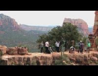 Group of hikers yoga position red cliff 