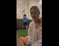 Girl uses guy in background sound punching bag 