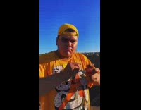 Guy in orange shirt with red spinning top yoyo does tricks