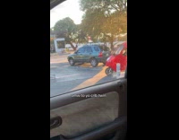 Small red car drives out parking lot