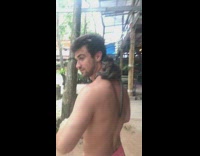 Small monkey hangs onto shirtless guys back 