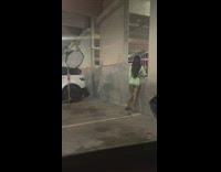 Woman green skirt hold railings parking garage
