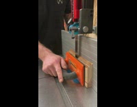 Guy cuts piece of wood using saw 