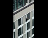 Collab WINY - Man cleans building window without safety rope