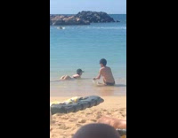 Man throws sand onto girls butt for picture