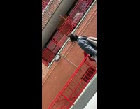 Girl grabs tote bag lowered from apartment 