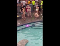 Woman in thin bikini poses near the crowd and the pool