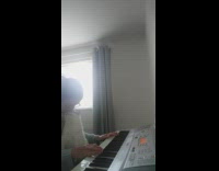 Cat cuddles with girl playing piano