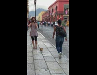 Lady sings on sidewalk while people dance