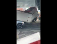 Cars Pass by Wrecked and Bent Truck