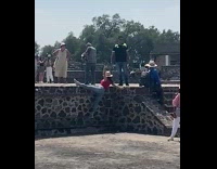 Woman in red top balances and hangs feet on the barrier
