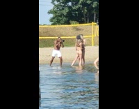 Two women in bikini with a captain hat at the beach