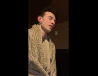 Guy with blanket wrapped around himself watches girl twerk 