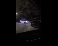 Car wrapped Christmas lights drives on road
