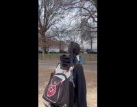Man balancing tire on head while riding bike 