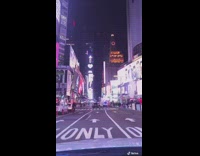 White car drives through times square night 