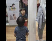 Little boy does happy dance in the mirror at uniqlo clothing store