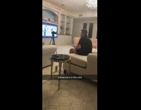 Guy on couch records video camera tripod 