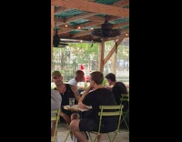 Guy across the street wears all red shirtless outfit 