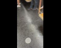 People riding subway stand because liquid on seats