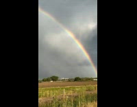 Beautiful double rainbow arc over farm fields