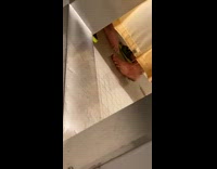 Two sets of feet inside of public shower 
