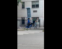 Man ride bicycle balance sofa over head