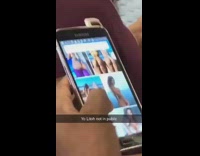 Man scrolls through pictures of naked woman on his phone on subway train