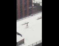 Man shirtless selfie stick spin snowy rooftop