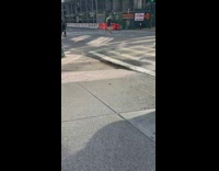 Guy and bulldog skateboard down street together 