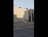 White trench coat lady concrete block asphalt