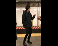 two men dancing salsa on subway platform