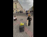 Woman black jacket sits on black luggage park